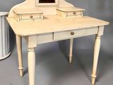 a small table with a mirror on it and a trash can next to it