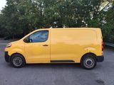 yellow van parked in a parking lot with trees in the background
