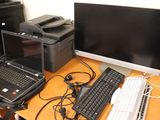 a desk with a computer, printer, and a laptop on it