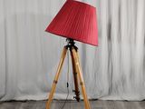 une lampe posée sur un trépied et munie d'un abat-jour rouge