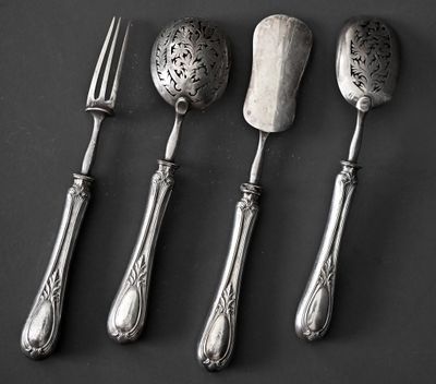 trois cuillères, une fourchette et un couteau posés sur un plan de travail noir