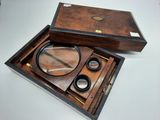 a wooden box with a magnifying lens and a magnifying glass