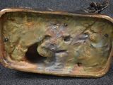 a bronze sculpture of a dog in a box