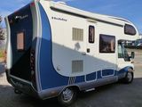 a white and blue rv parked on the side of the road