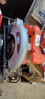 quelqu'un utilise une scie circulaire pour couper une pièce de bois