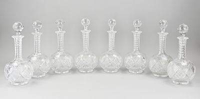 six vases en verre transparent sont alignés sur une surface blanche