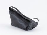 le petit sac noir est posé sur une surface blanche