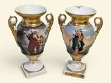 two vases with pictures on them sitting on a table