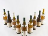 six bottles of wine are lined up in a row on a white surface