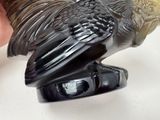 a black and gold bird statue on a white surface