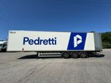 a white semi truck with a blue and white logo parked in a parking lot