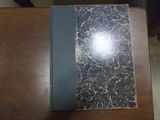 un livre posé sur une table en bois, avec une couverture noire