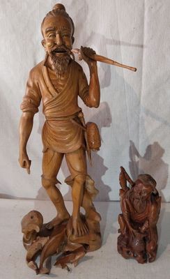 une statue représentant un homme tenant un bâton, à côté d'une statue représentant un chien
