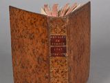 an old book sitting on top of a table next to a gray wall