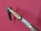 a close up of a cane with a handle on a red wall