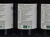 three bottles of wine sitting on a glass shelf
