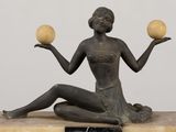 statue of a woman sitting on a marble block holding two apples