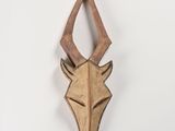 a close up of a wooden animal head mounted on a wall