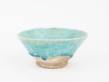 a small blue bowl with a brown base on a white surface