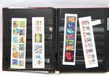 un livre ouvert, orné de timbres, posé sur une surface blanche