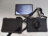 a camera and a tablet on a bed with a strap
