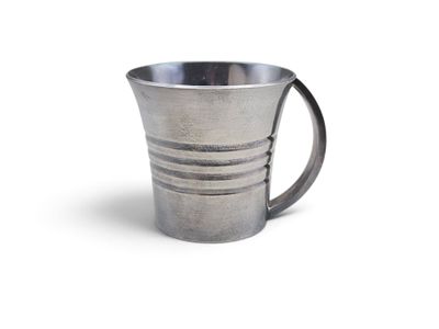 une tasse en argent posée sur une surface blanche