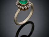 a close up of a gold ring with a green stone