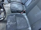 a dirty seat in the back of a car that is parked on the side of the street