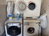 deux lave-linge et un sèche-linge dans une petite pièce