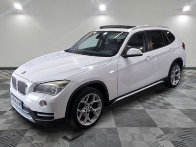 the white bmw suv is parked in a large room