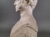 marble bust of a man in profile with a shield on his shoulder