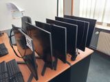 four computer monitors on a desk with a keyboard and mouse