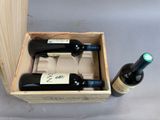 three bottles of wine in a wooden box on a table