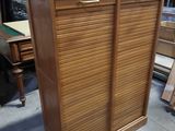 une armoire en bois avec une porte coulissante au milieu
