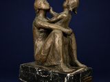 bronze statue of a man and a woman sitting on a marble base