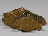 figurine en bronze représentant une femme assise sur une feuille, posée sur un fond blanc