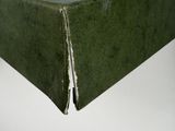 an old green book sitting on top of a white table