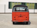 an orange and black vw bus parked in front of a building