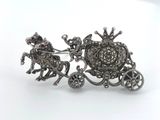 an image of a silver broochle with a horse drawn carriage