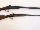 trois vieilles armes à feu posées sur une table, sur fond blanc