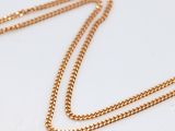 a close up of a gold chain on a white surface