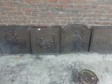three cast iron fire boxes sitting on a sidewalk next to a brick wall
