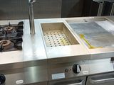 a kitchen with a sink, stove, and oven in it