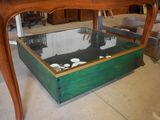 une table en bois avec un plateau en verre et un tiroir en dessous