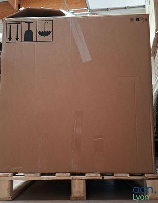 un carton posé sur une palette dans une pièce