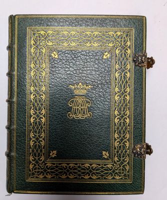 un livre en cuir vert, orné de bordures dorées et d'un motif décoratif