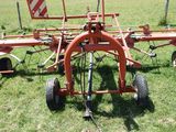 a tractor that is sitting in the grass with a plow attached to it