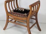 a small wooden chair with a black cushion on it