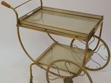 brass bar cart with glass shelves and wooden handles