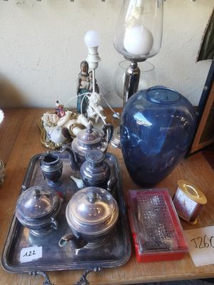 un plateau avec des couverts et un vase bleu posé sur une table